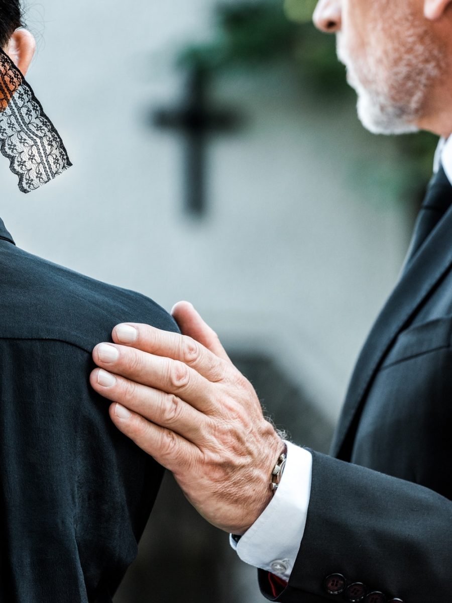 cropped-view-of-man-touching-woman-on-funeral.jpg